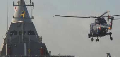 A Royal Danish Navy Super Lynx Mk 90B performs a landing on the Swedish corvette HMS VISBY