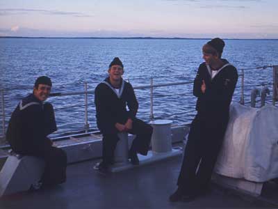 Tre af fregattens orlogsgaster nyder solnedgangen på agterdækket